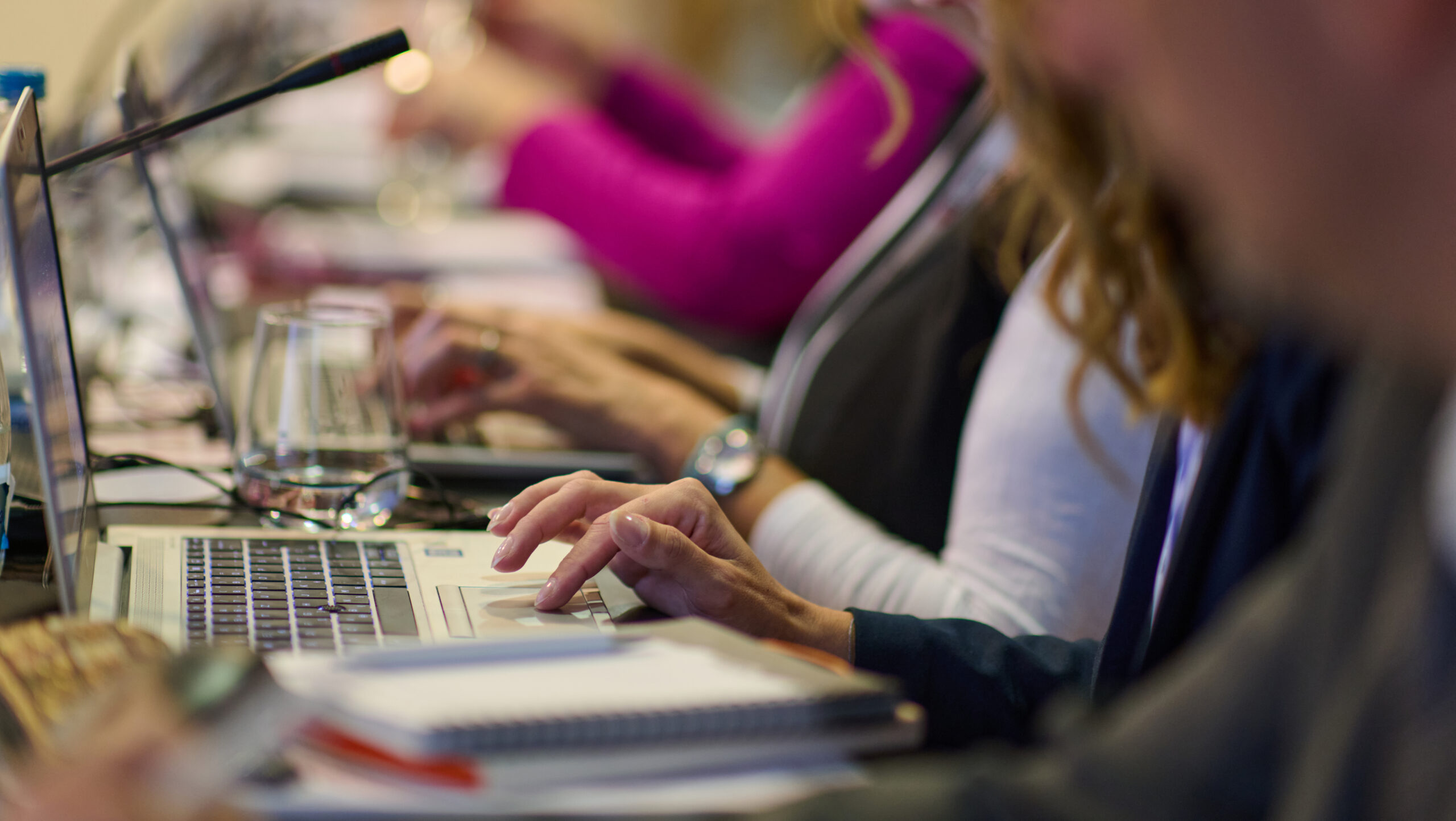 Business professionals engage in strategic discussions and project planning during a crucial seminar, utilizing laptops and papers to drive collaborative decision making.